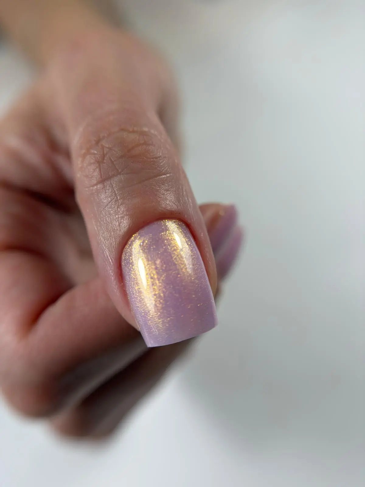Uñas lilas con brillo dorado